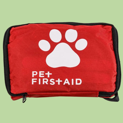Red pet first aid kit with a white paw print and 'Pet First Aid' text on a green background