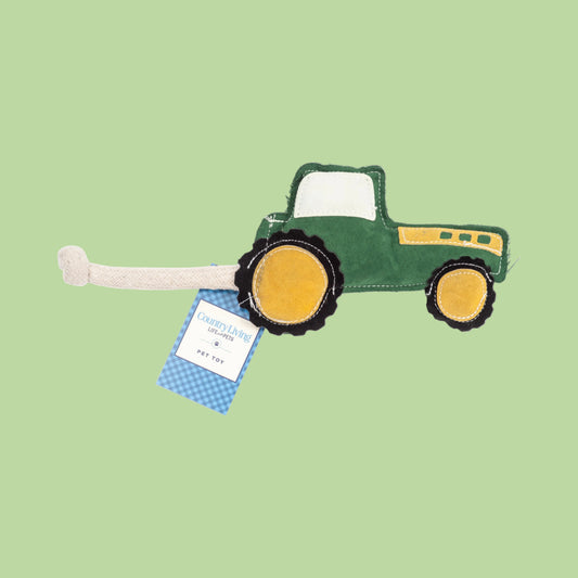 Green tractor-shaped toy with a tag on a white background