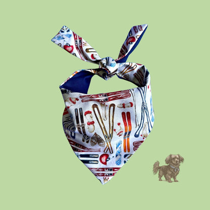 Ski slopes dog bandana on a green background with a small dog illustration.