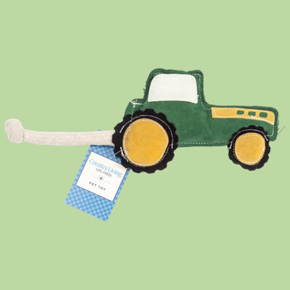 Green tractor-shaped toy with a tag on a white background